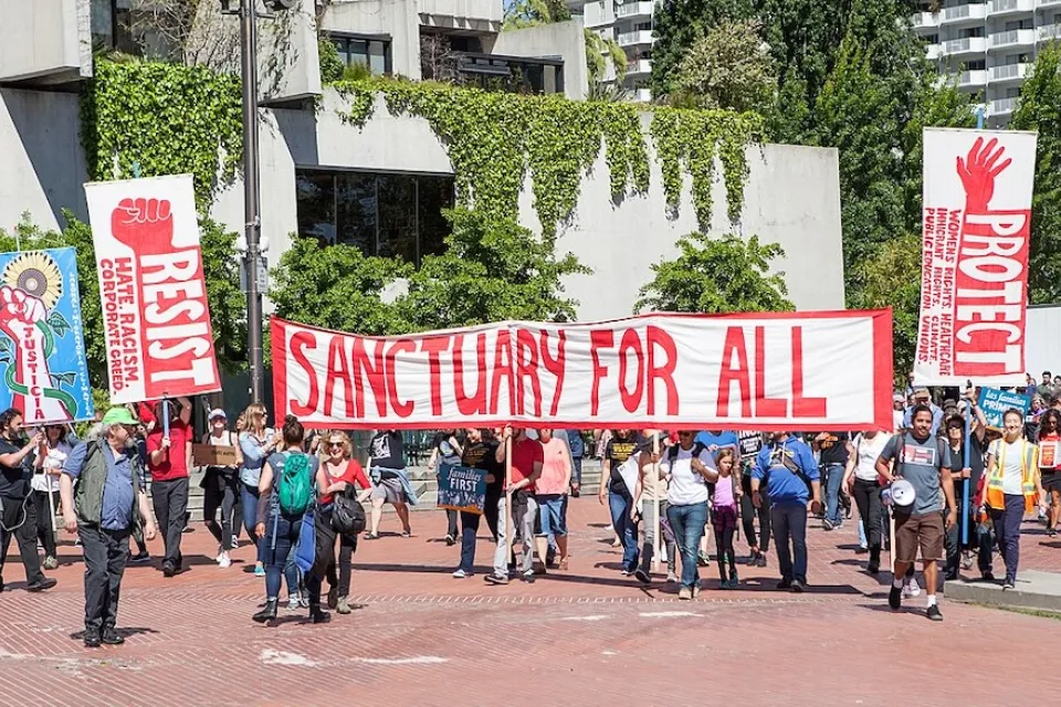 Group protesting during May Day 2017 holding sign that reads "Sanctuary for all" in San Francisco, California.
